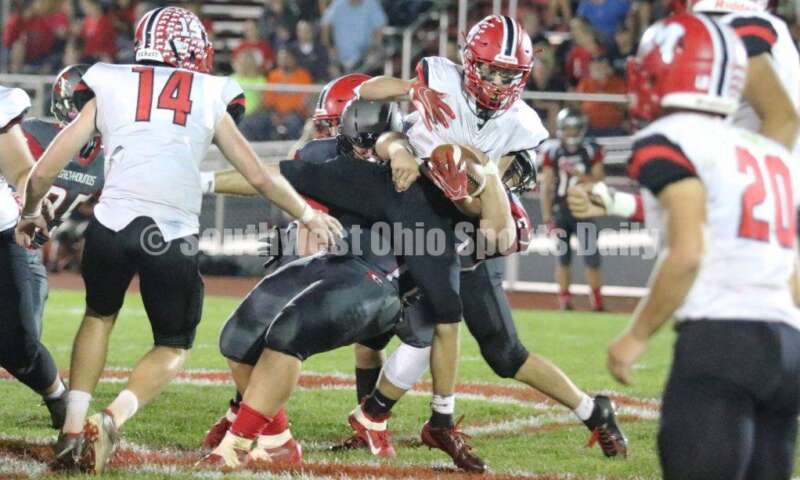 Madison High School's Chase Patrick (13) is grabbed by Dixie's Billy Womble (67) on Oct. 3, 2019, during a Southwestern Buckeye League football game at Dixie. The visiting Mohawks won 48-13. RICK CASSANO/STAFF