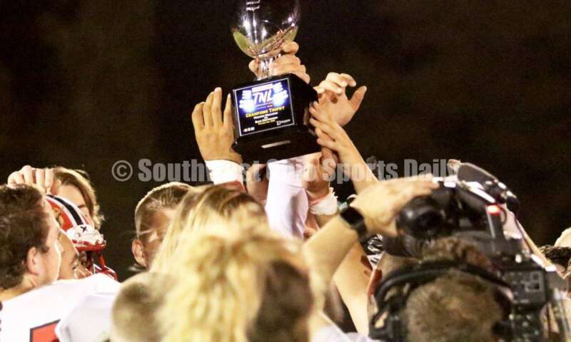 Madison High School's football team holds up the Thursday Night Lights trophy Oct. 3, 2019, after a Southwestern Buckeye League football game at Dixie. The visiting Mohawks won 48-13. RICK CASSANO/STAFF