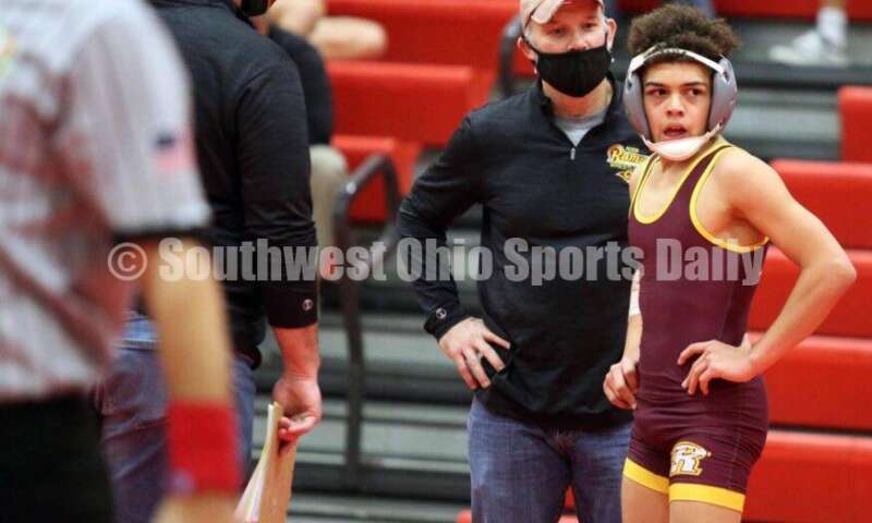 Ross High School's Jordan Miller talks with coach Rich Dunn during a 113-pound contest against Blanchester's Jacob Hamm on Jan. 13, 2021, in a dual wrestling match at New Richmond. RICK CASSANO/STAFF