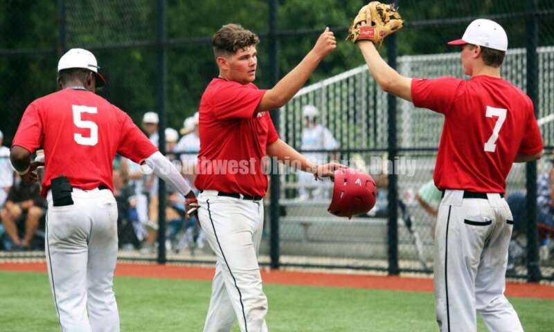 Lakota West High School's Adrian Davis (5) and Colin Harrington (middle) and Lakota East's Will Becker (7) celebrate a run for the Cincinnati Impact on June 25, 2021, during Pastime Tournaments' Ohio Valley 17U/18U Wood Bat Classic at New Richmond. The Impact beat Sluggers Baseball Club 3-2. RICK CASSANO/STAFF
