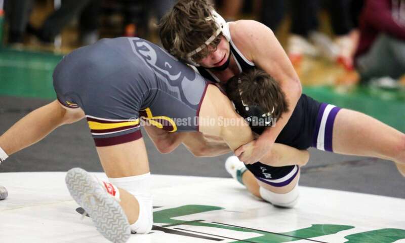 Ross High School's Jovanni Greco (left) and Elder's Joey Thamann square off in a 113-pound match Dec. 19, 2021, during the Southwest Ohio Wrestling Coaches Association Coaches Classic at Harrison High School. RICK CASSANO/STAFF
