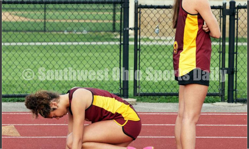 Ross High School's Caroline Chernock helps teammate Myah Boze by securing the block in the girls 300-meter hurdles April 16, 2024, during the Dale Plank Invitational track & field meet at Talawanda. RICK CASSANO/STAFF