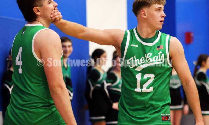 Harrison High School's Tucker Ward (12) quiets teammate Brody Mumfrey after tempers flared on the court Dec. 8, 2025, during a boys basketball game at Reading. Harrison won 62-42. RICK CASSANO/STAFF